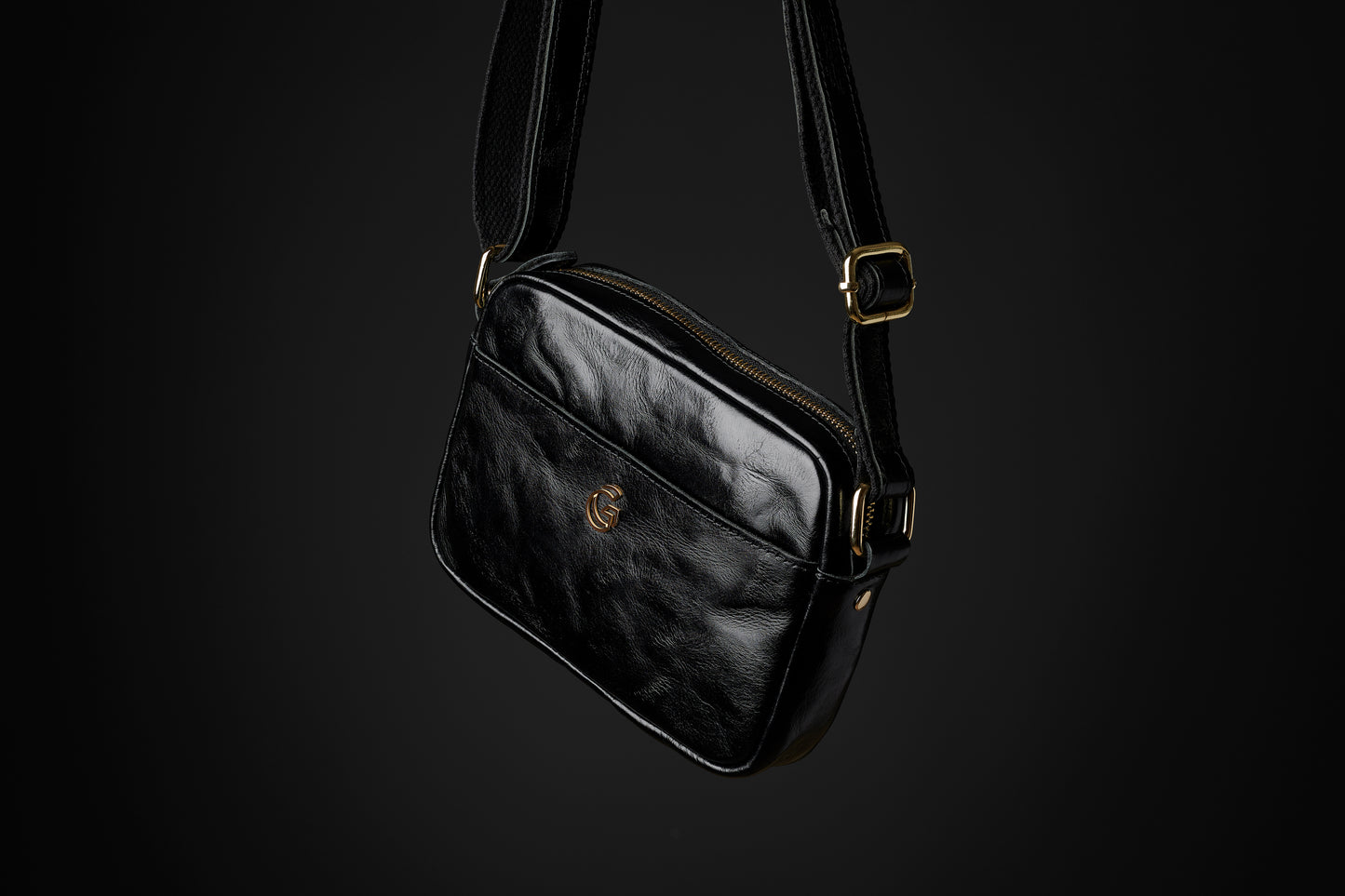 the Acolyte black leather cross body bag with gold hardware